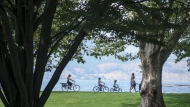 A family cycles along Lake Okanagan in Kelowna, B.C., Wednesday, Aug. 31, 2022.THE CANADIAN PRESS/Jeff McIntosh