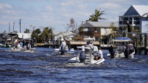 FILE - Boats operated by resident good Samaritans help evacuate residents who stayed behind on Pine Island, in the aftermath of Hurricane Ian in Matlacha Fla., Sunday, Oct. 2, 2022. The only bridge to the island is heavily damaged so it can only be reached by boat or air. The devastation from Hurricane Ian has left schools shuttered indefinitely in parts of Florida, leaving storm-weary families anxious for word on when and how children can get back to classrooms. (AP Photo/Gerald Herbert, File)