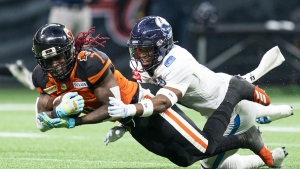 BC Lions' Lucky Whitehead (left) catches a pass and gets tackled by Toronto Argonauts' DaShaun Amos during second half of CFL football action in Vancouver on June 25, 2022. Toronto (8-6) hosts B.C. (10-4) on Saturday night at BMO Field. THE CANADIAN PRESS/Rich Lam