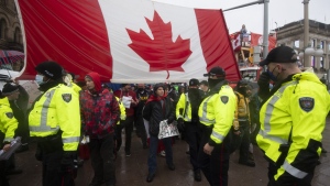 Police attempt to hand out notices on the 21st day of the "Freedom Convoy" protest, in Ottawa, on Thursday, Feb. 17, 2022. THE CANADIAN PRESS/Justin Tang