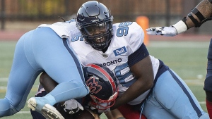 Montreal Alouettes quarterback Trevor Harris, bottom, is brought down by Toronto Argonauts' Sam Acheampong (96) during first half CFL football action in Montreal, Saturday, October 22, 2022. THE CANADIAN PRESS/Graham Hughes