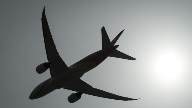 A plane is silhouetted as it takes off from Vancouver International Airport in Richmond, B.C., Monday, May 13, 2019. As inflation remains hot around the world, Canadians trying to escape the cold this winter will be looking to save during the peak travel season. THE CANADIAN PRESS/Jonathan Hayward