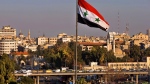 In this Feb. 28, 2016 file photo a Syrian national flag waves as vehicles move slowly on a bridge during rush hour, in Damascus, Syria. (AP Photo/Hassan Ammar, file) 