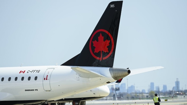 Airline ground crew walks past grounded Air Canada planes as they sit on the tarmac at Pearson International Airport in Toronto on Tuesday, April 27, 2021. THE CANADIAN PRESS/Nathan Denette