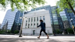 A woman walks past the Bank of Canada headquarters, Wednesday, June 1, 2022 in Ottawa. THE CANADIAN PRESS/Adrian Wyld