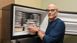 Rafi Aaron, the co-coordinator of St. Luke's Out of the Cold meal program, loads some prepared meals into a freezer at the downtown east church.