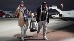 Coach Ryan Dinwiddie and linebacker Henoc Muamba of the Toronto Argonauts hold the Grey Cup as they arrive at Toronto Pearson International Airport in Mississauga, Ont., Monday, Nov. 21, 2022. The Argonauts defeated the Winnipeg Blue Bombers on Sunday to win the cup. THE CANADIAN PRESS/Arlyn McAdorey