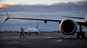 A ground worker walks under one of the wings of a WestJet Airlines Boeing 737 Max aircraft after it arrived at Vancouver International Airport, in Richmond, B.C., Thursday, Jan. 21, 2021. Canada's Transport Minister met with airlines and airports to ensure reliable service for travellers ahead of what is expected to be a busy travel season. THE CANADIAN PRESS/Darryl Dyck