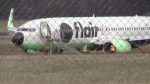 A Flair Airlines plane is shown in a grassy field after exiting the runway at an airport in Waterloo on Friday. 