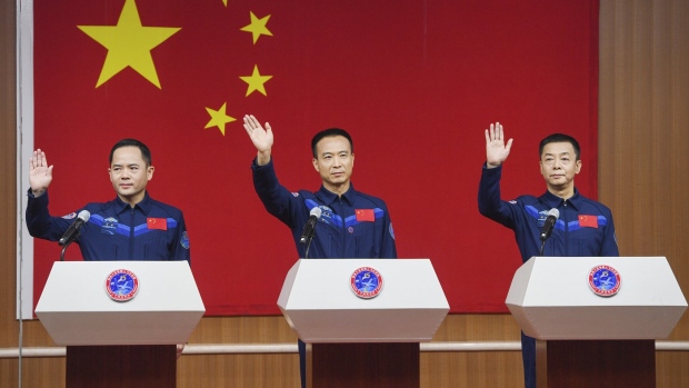 In this photo released by Xinhua News Agency, from left, Chinese astronauts for the upcoming Shenzhou-15 mission Zhang Lu, Fei Junlong and Deng Qingming wave during a meeting of the press at the Jiuquan Satellite Launch Center in northwest China on Monday, Nov. 28, 2022. Final preparations were being made Monday to send the new three-person crew to China's space station as it nears completion amid intensifying competition with the United States. (Liu Lei/Xinhua via AP)