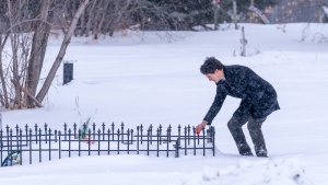 Prime Minister Justin Trudeau lays tobacco in front of a grave of one of the victims of a mass stabbing at James Smith Cree Nation, Sask., on Monday, Nov. 28, 2022. THE CANADIAN PRESS/Heywood Yu