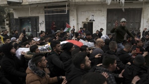 Palestinian mourners carry the body of Mufid Khalil during his funeral in the West Bank village of Beit Ummar, near Hebron, Tuesday, Nov. 29, 2022. Khalil was killed by Israeli fire in the occupied West Bank, the Palestinian Health Ministry said Tuesday. The Israeli military said soldiers shot at Palestinians who hurled rocks and improvised explosive devices and shot at the troops. (AP Photo/Mahmoud Illean)
