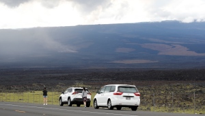 Spectators pull over on Saddle Road to watch the eruption on Mauna Loa, Tuesday, Nov. 29, 2022, near Hilo, Hawaii. (AP Photo/Marco Garcia)