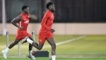 Canada forward Alphonso Davies, right, runs with teammate Jonathan David during practice at the World Cup in Doha, Qatar, on Tuesday, Nov. 29, 2022. THE CANADIAN PRESS/Nathan Denette
