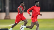 Canada forward Alphonso Davies, right, runs with teammate Jonathan David during practice at the World Cup in Doha, Qatar on Tuesday, November 29, 2022. THE CANADIAN PRESS/Nathan Denette 