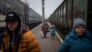 Natalia Korsh, 72, center left, walks with her granddaughter Veronika, 5, along the platform during their evacuation in Kherson, Ukraine, Thursday, Dec. 1, 2022. Four members of the family decided to go to Kyiv after their house was damaged by Russian shelling. (AP Photo/Evgeniy Maloletka)