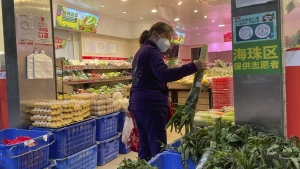 A woman shops in a reopened grocery store in the district of Haizhu as pandemic restrictions are eased in southern China's Guangzhou province, Thursday, Dec. 1, 2022. (AP Photo)