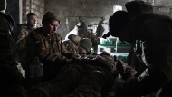 Ukrainian servicemen give the first aid to a soldier wounded in a battle with the Russian troops in their shelter in the Donetsk region, Ukraine, Thursday, Dec. 1, 2022. (AP Photo/Roman Chop)