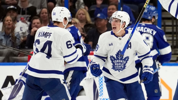 Toronto Maple Leafs right wing Mitchell Marner (16) celebrates his goal against the Tampa Bay Lightning with center David Kampf (64) during the second period of an NHL hockey game Saturday, Dec. 3, 2022, in Tampa, Fla. (AP Photo/Chris O'Meara)