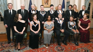 2022 Kennedy Center Honoree George Clooney, bottom third from right, reacts as he is given a shoulder rub from fellow 2022 Honoree Bono during a group photo at the State Department following the Kennedy Center Honors gala dinner, Saturday, Dec. 3, 2022, in Washington. Also with Clooney are, front row from left, Evan Ryan, Amy Grant, Gladys Knight, Tania León, Deborah Rutter, back row from left, Antony Blinken, David Rubenstein, Adam Clayton, Larry Mullen Jr., The Edge, Bono, Kennedy Center Honor Producers David Jammy, Liz Kelly and Ian Stewart (AP Photo/Kevin Wolf)