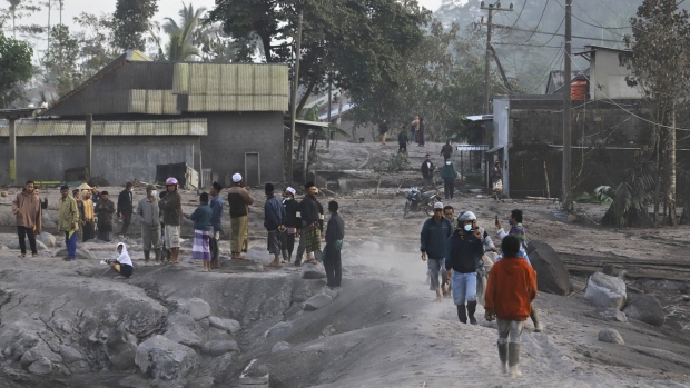 People inspect their ash-covered village