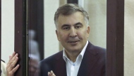 FILE - Former Georgian President Mikheil Saakashvili, who was convicted in absentia of abuse of power during his presidency and arrested upon his return from exile, gestures speaking from a defendant's dock during a court hearing in Tbilisi, Georgia, on Dec. 2, 2021. The main opposition party in Georgia has filed a court case calling for the imprisoned ex-president of the country to be released for medical examination overseas because of concerns that he is suffering from poisoning. (Irakli Gedenidze/Pool Photo via AP, File)