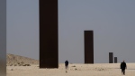 People overlook famous American artist Richard Serra's 'East-West/West-East' art as it stands in a desolate section of the Brouq nature reserve in the northwestern part of the country's desert close to Zekreet, Qatar on Saturday, December 3, 2022. Four steel plates, each 14 metres high, span a one-kilometer stretch of the desert. THE CANADIAN PRESS/Nathan Denette