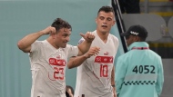Switzerland's Xherdan Shaqiri, left, celebrates with his teammate Granit Xhaka after scoring his side's opening goal during the World Cup group G soccer match between Serbia and Switzerland, at the Stadium 974 in Doha, Qatar, Friday, Dec. 2, 2022. (AP Photo/Martin Meissner)