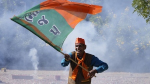 A Bharatiya Janata party (BJP) supporter celebrates lead for the party in Gujarat state elections in Gandhinagar, India, Thursday, Dec. 8, 2022. Indian Prime Minister Narendra Modi’s Hindu nationalist party is all set to keep its 27-year-old control of his home Gujarat state in a record state legislature win. (AP Photo/Ajit Solanki)