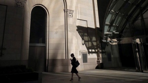A woman walks through Toronto's financial district on Monday, July 30, 2018. A new report recommends Canada's corporate boards should have at least 40 per cent women and 30 per cent members of underrepresented racial groups or identifying as Indigenous or disabled. THE CANADIAN PRESS/Graeme Roy