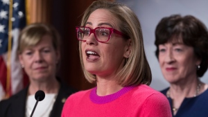 FILE - Sen. Kyrsten Sinema, D-Ariz., flanked by Sen. Tammy Baldwin, D-Wis., left, and Sen. Susan Collins, R-Maine, speaks to reporters following Senate passage of the Respect for Marriage Act, at the Capitol in Washington, Tuesday, Nov. 29, 2022. Though elected as a Democrat, Sinema announced Friday, Dec. 9, that she has registered as an Independent, but she does not plan to caucus with Republicans, ensuring Democrats will retain their narrow majority in the Senate. (AP Photo/J. Scott Applewhite, File)