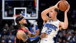 Orlando Magic's Franz Wagner (22) looks to pass the ball as Toronto Raptors' Gary Trent Jr. defends during the second half of an NBA basketball game Friday, Dec. 9, 2022, in Orlando, Fla. (AP Photo/John Raoux)