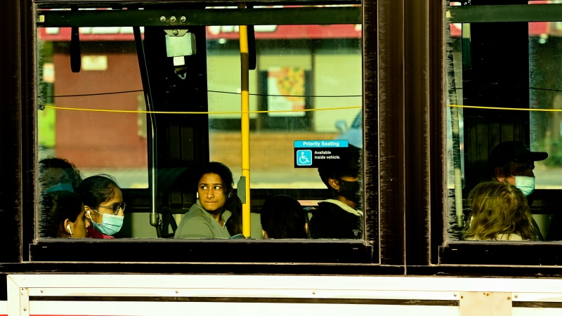 A person rides a city bus while commuting at rush hour during the COVID-19 pandemic in Toronto on Friday, October 9, 2020. THE CANADIAN PRESS/Nathan Denette