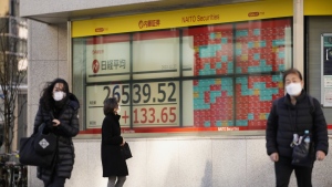 woman looks at Japan's Nikkei 225 index