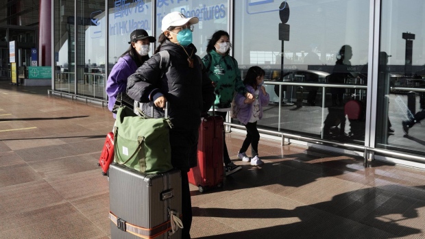 FILE - Passengers wearing masks walk through the Capital airport terminal in Beijing on Dec. 13, 2022. On Wednesday, Dec. 28, 2022, the U.S. announced new COVID-19 testing requirements for all travelers from China, joining other nations imposing restrictions because of a surge of infections. (AP Photo/Ng Han Guan, File)