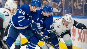 Seattle Kraken defenceman Vince Dunn (29) battles with Toronto Maple Leafs centre Alexander Kerfoot (15) and centre David Kampf (64) during second period NHL action in Toronto on Thursday January 5, 2023. THE CANADIAN PRESS/Frank Gunn