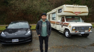 Lucas Philips is pictured outside his camper and next to his Tesla in a parking lot where he has been living at Spanish Banks, in Vancouver, B.C., Thursday, Dec. 8, 2022. Philips is part of Metro Vancouver's camper community, some living on wheels as an economic strategy, some as a lifestyle choice and others as a last resort. THE CANADIAN PRESS/Jonathan Hayward