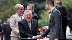 Outgoing Ontario Lieutenant-Governor David Onley, centre, laughs as he and his wife Ruth Ann, left, are greeted by staff while arriving for his final full day in office at Queen's Park in Toronto on Monday, September 22, 2014. THE CANADIAN PRESS/Darren Calabrese 