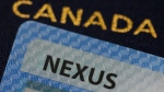 A NEXUS card and a Canadian passport are pictured in Ottawa on Tuesday, Jan. 17, 2023. Canada and the United States are detailing how their new bilateral workaround for the Nexus trusted-traveller system is going to work. THE CANADIAN PRESS/Sean Kilpatrick
