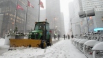 A worker plows a sidewalk in Toronto's financial district as a winter storm starts to hit the city Wednesday, Jan. 25, 2023. THE CANADIAN PRESS/Graeme Roy
