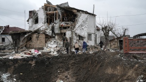 A crater of an explosion is seen next to a destroyed house after a Russian rocket attack in Hlevakha, Kyiv region, Ukraine, Thursday, Jan. 26, 2023. (AP Photo/Roman Hrytsyna)
