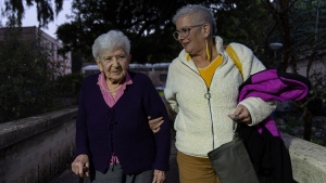 Holocaust survivor Sarah Epstein, left, and her daughter Tali arrive at a ceremony awarding the Jewish Rescuers Citation to members of the Zionist youth movement underground in Hungary during the Holocaust, at Kibbutz HaZorea, northern Israel, Tuesday, Dec. 13, 2022. Just before Nazi Germany invaded Hungary in March 1944, Jewish youth leaders in the eastern European country jumped into action: they formed an underground network that in the coming months would rescue tens of thousands of fellow Jews from the gas chambers. (AP Photo/Tsafrir Abayov)