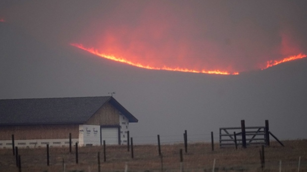 Flames rise from mountain ridges 