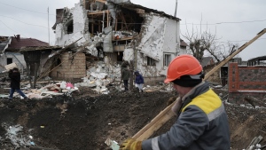 People clean a destroyed residential area after a Russian rocket attack in Hlevakha, Kyiv region, Ukraine, Thursday, Jan. 26, 2023. (AP Photo/Roman Hrytsyna)