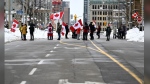 Demonstrators stand on Wellington Street as they mark the one year anniversary of the Freedom Convoy in Ottawa, on Saturday, Jan. 28, 2023. THE CANADIAN PRESS/Justin Tang