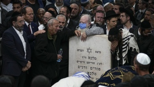 Mourners attend the funeral of Israeli couple Eli Mizrahi and his wife, Natalie, victims of a shooting attack Friday in east Jerusalem, at the cemetery in Beit Shemesh, Israel, early Sunday, Jan. 29, 2023. On Friday a Palestinian gunman opened fire outside an east Jerusalem synagogue, killing the couple and another five people, including a 70-year-old woman, and wounding three others before he was shot and killed by police, officials say. It was the deadliest attack on Israelis since 2008 and raised the likelihood of more bloodshed. (AP Photo/Ariel Schalit)