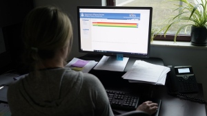 Case work supervisor Jessie Schemm looks over the first screen of software used by workers who field calls at an intake call screening center for the Allegheny County Children and Youth Services, in Penn Hills, Pa. The Justice Department is scrutinizing a controversial artificial intelligence tool used by a Pittsburgh-area child protective services agency following concerns that it could result in discrimination against families with disabilities, The Associated Press has learned. (AP Photo/Keith Srakocic, File)