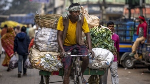 A man on his tricycle carries transports vegetables at a wholesale market in Guwahati, India, Wednesday, Feb. 1, 2023. Indian Prime Minister Narendra Modi's government ramped up capital spending by a substantial 33% to $122 billion in an annual budget presented to Parliament on Wednesday, seeking to spur economic growth and create jobs ahead of a general election next year. (AP Photo/Anupam Nath)