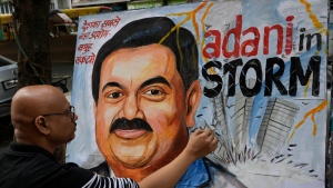 Sagar Kambli, an artist and a school teacher, gives final touches to a painting of Indian businessman Gautam Adani, depicting the ongoing crisis of the Adani group, in Mumbai, India, Friday, Feb. 3, 2023. Losses for the troubled Adani Group, India's second-largest conglomerate, deepened on Friday as shares in its flagship company tumbled another 25%, extending over a week of declines that have wiped out tens of billions of dollars in market value. (AP Photo/Rajanish Kakade)