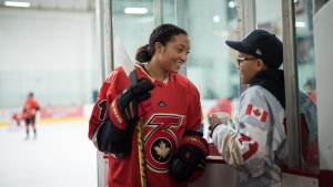 Saroya Tinker of the Premier Hockey Federation's Toronto Six is greeted by her brother Malachi, 12, after an on-ice warm-up before a home game against the Connecticut Whale, at Canlan Sports at York University in Toronto, on Saturday, Jan. 21, 2023. THE CANADIAN PRESS/ Tijana Martin.